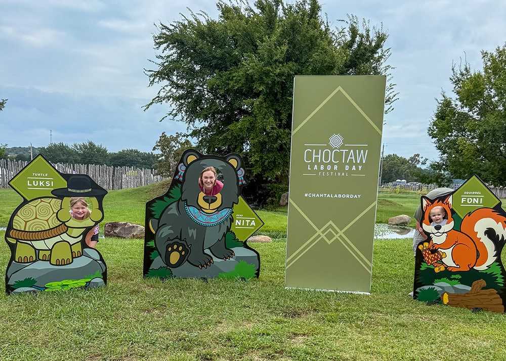 A family poses for a photo in cutouts of animals.
