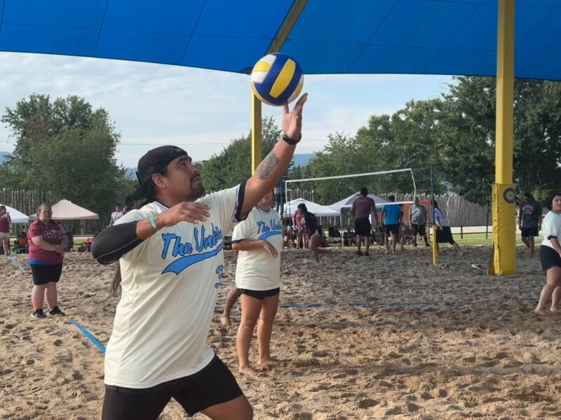 A man serves a volleyball