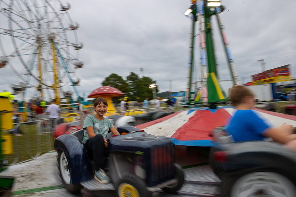 Kids ride a carnival ride.