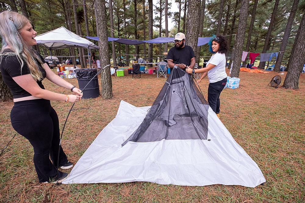 A family sets up a tent.