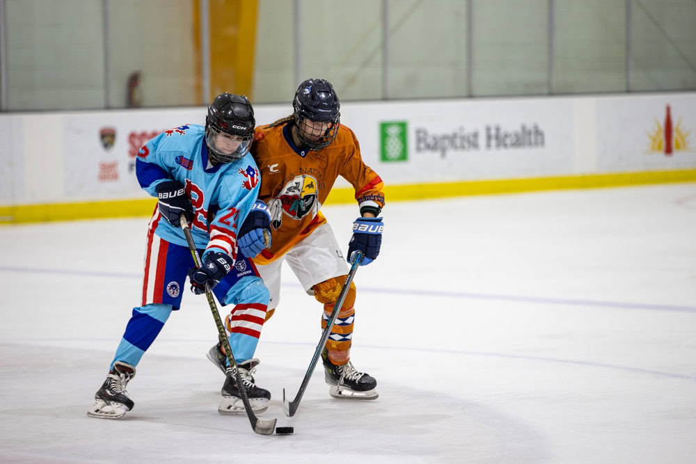A hockey player in a blue and red uniform and a hockey player in an oragn