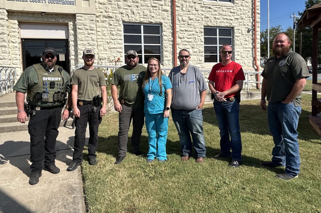 Police officers and staff pose for a photo.