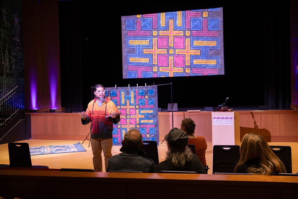 A man speaks from the stage.