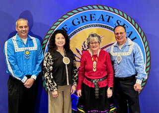 A woman poses with tribal leadership.