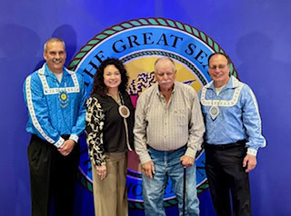 A man poses with tribal leadership. 