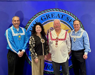 A man poses with tribal leadership.
