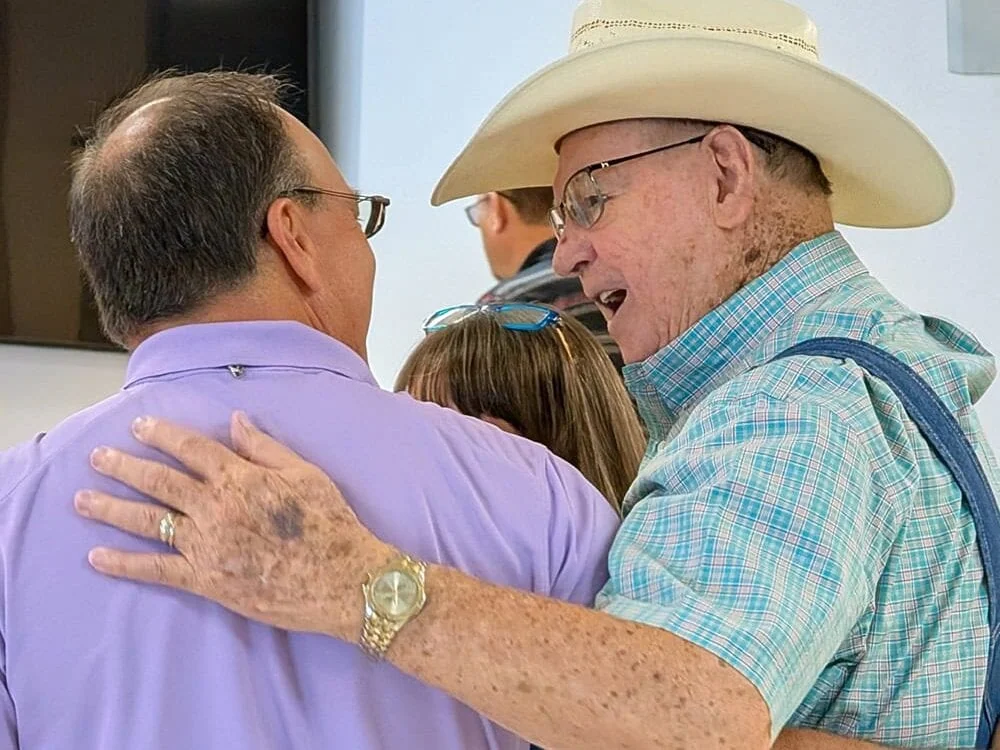 Two men great each other warmly.