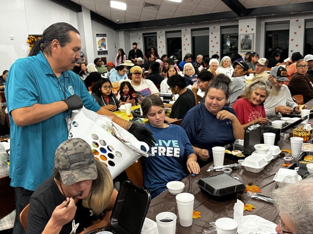 A volunteer collects trash from a table.