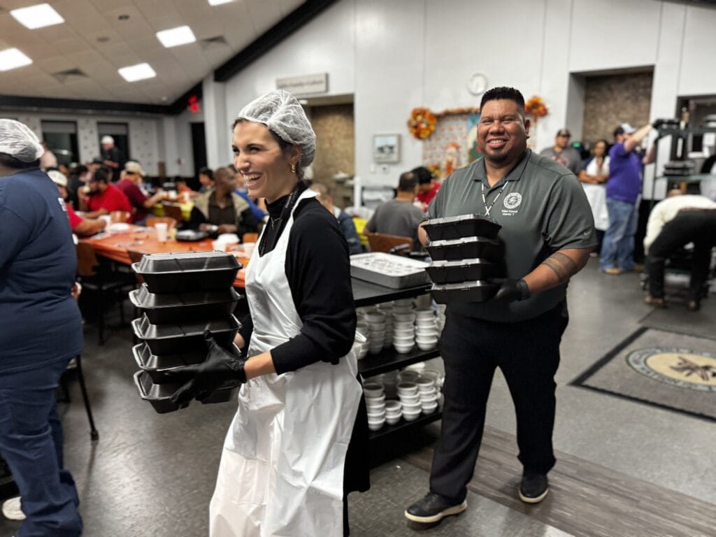 Joey Tom and a volunteer hand out meals.