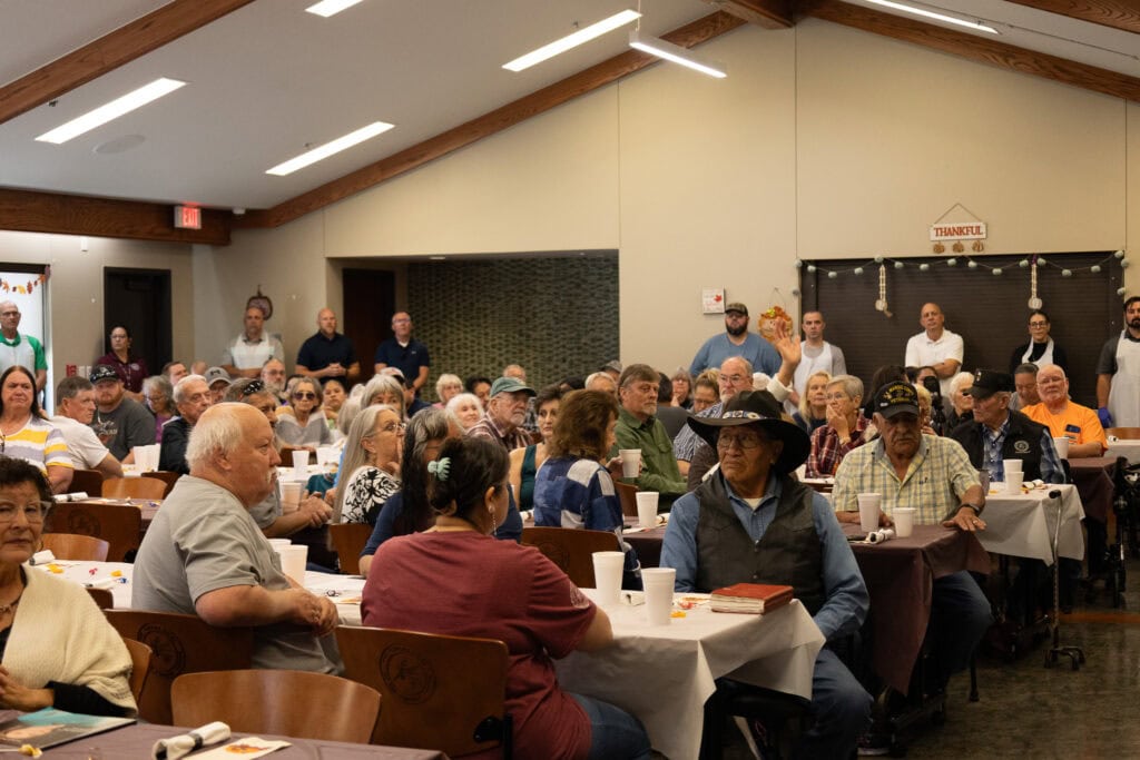 Antler's elders sit and wait for meal.