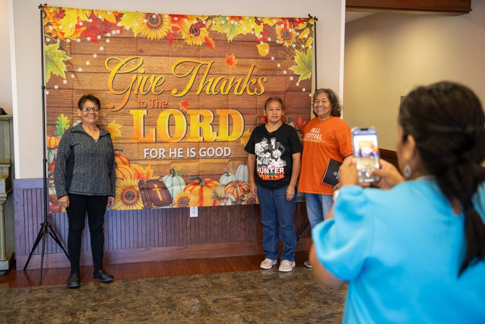 Women pose for a photo as another takes the picture.