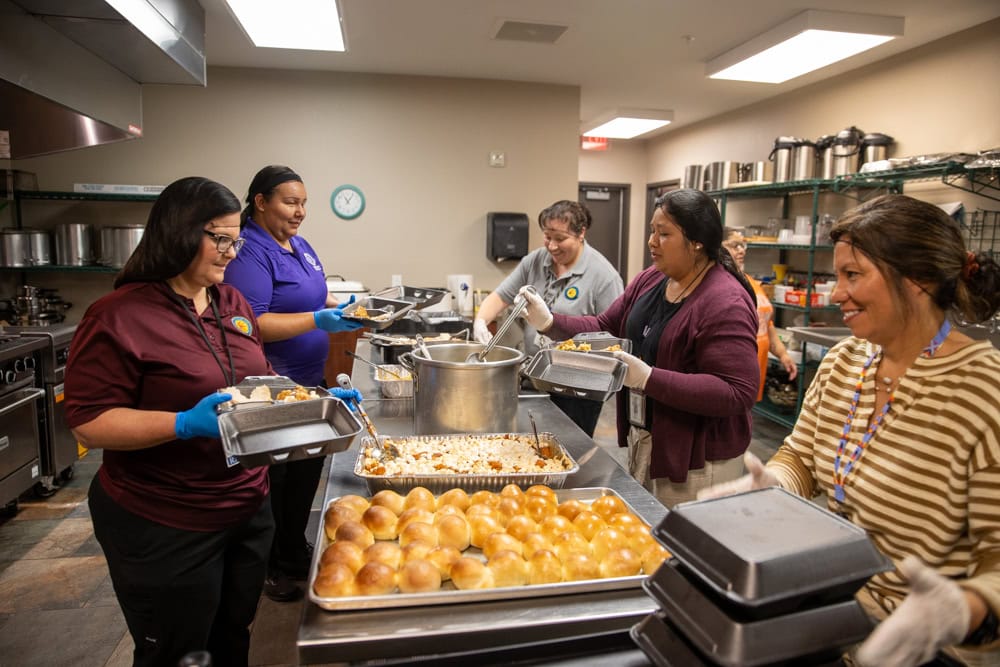 Volunteers dish out rolls.