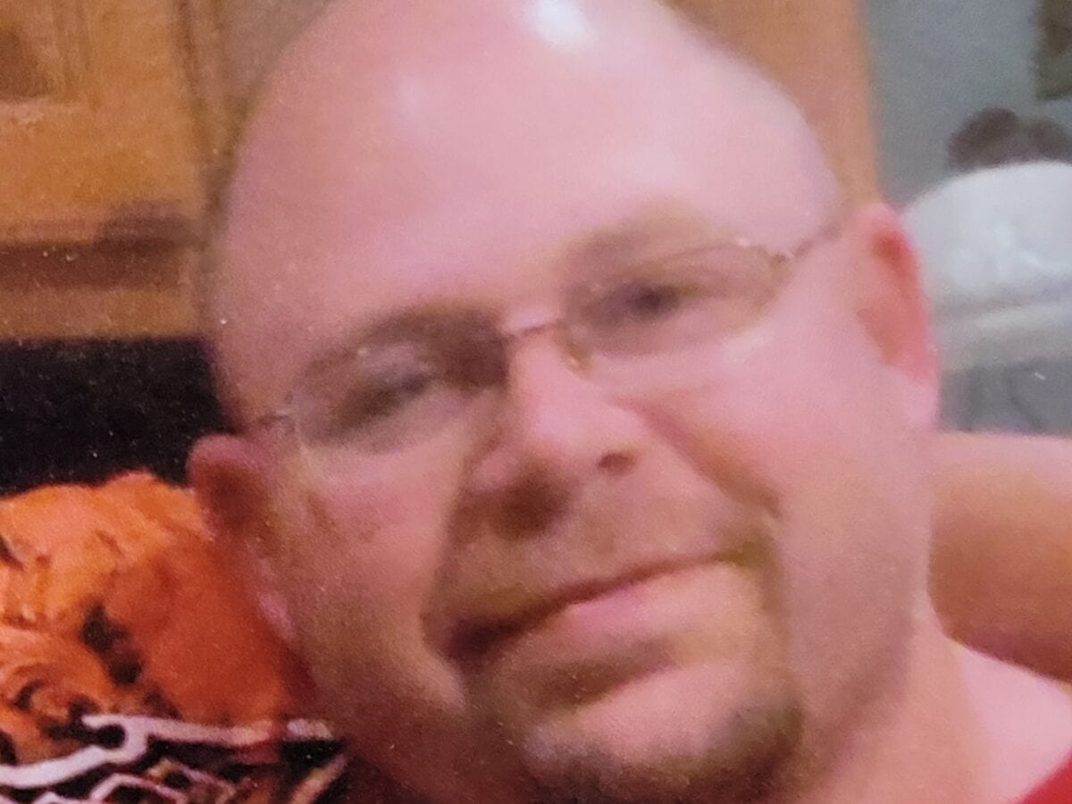 Man wearing glasses smiles for photo.