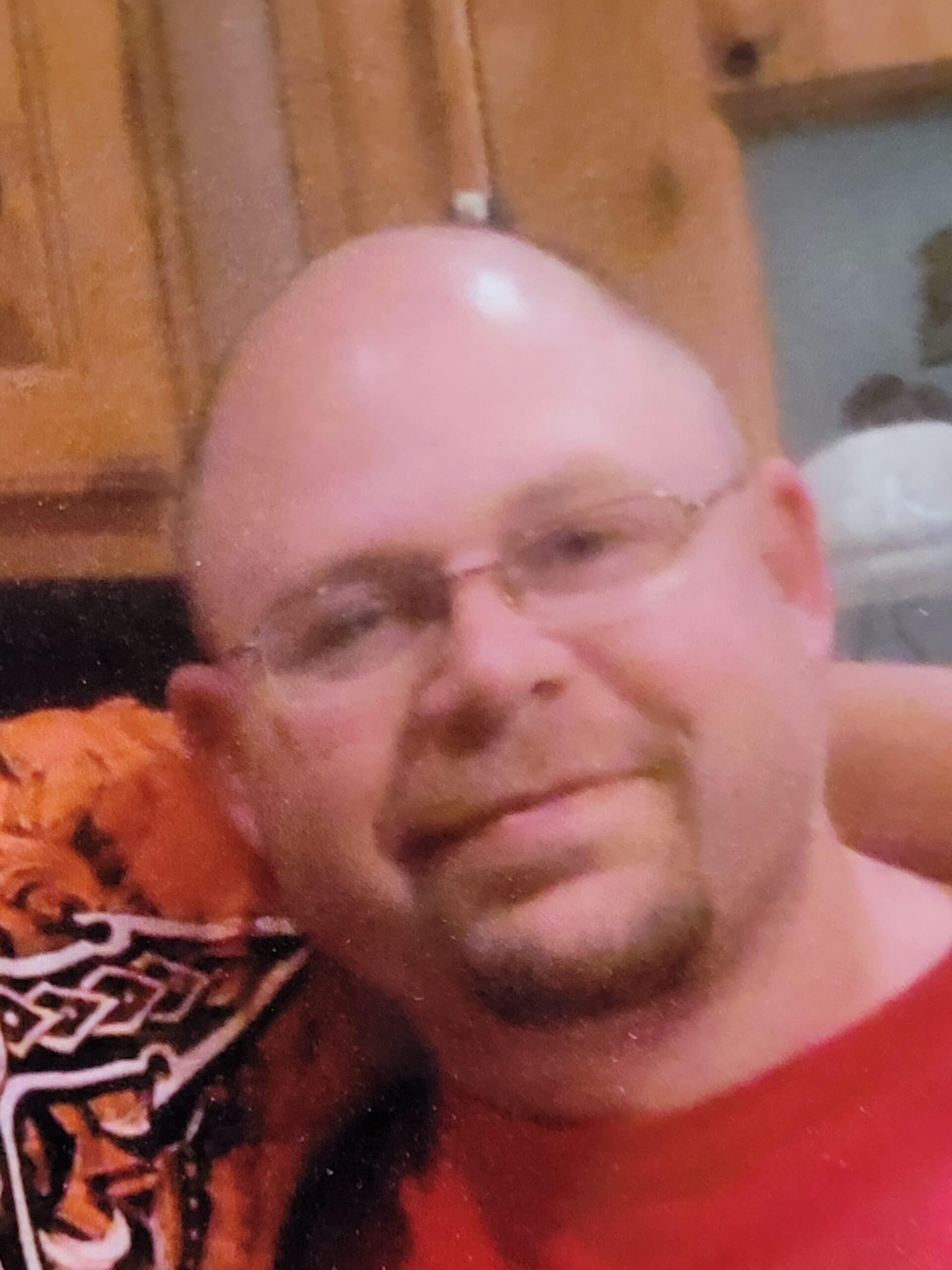 Man wearing glasses smiles for photo.