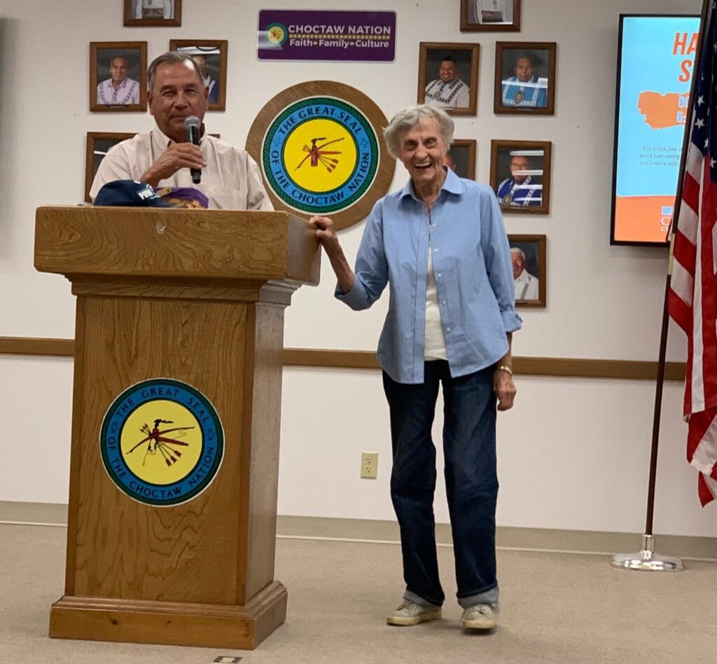 Charlene Dunn stands at podium with Jess Henry.