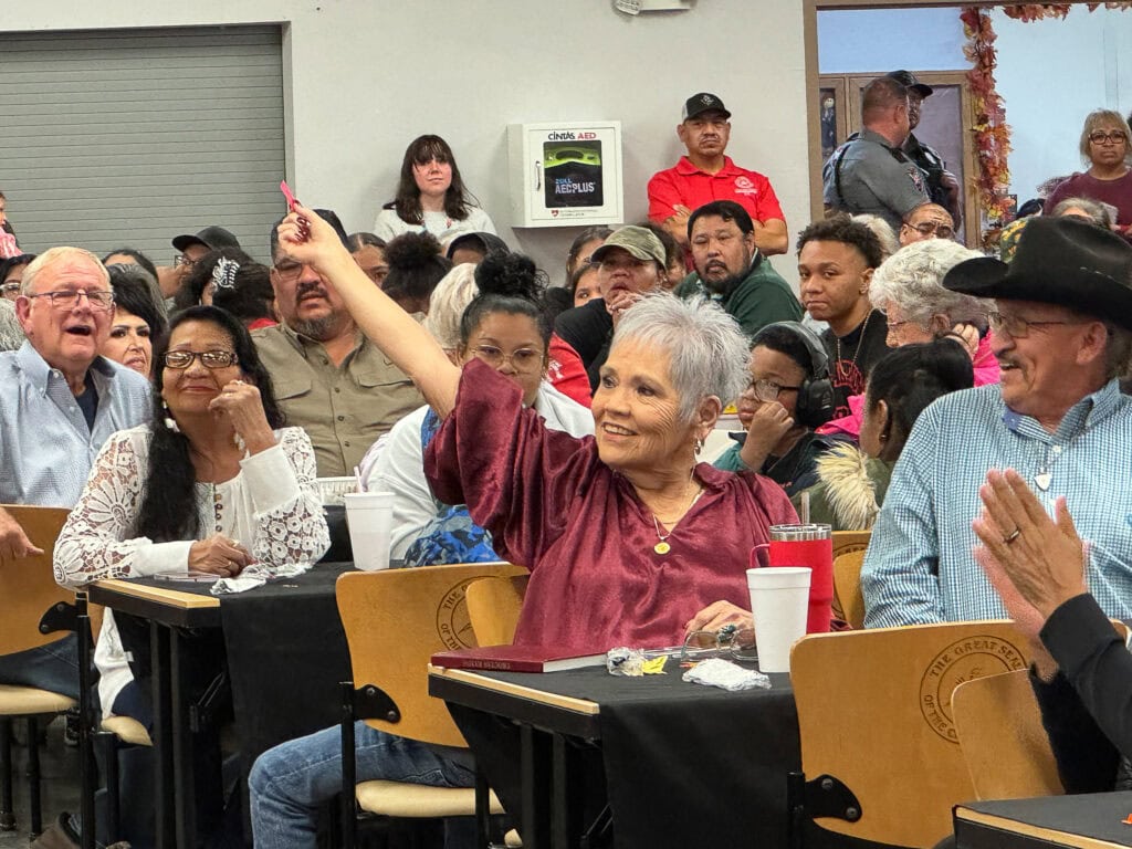 An elder raises her hand.