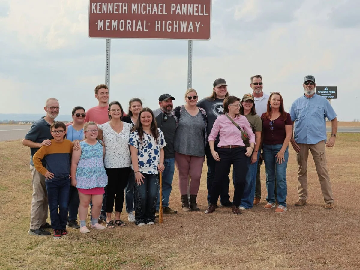 The family of Mike Pannell stand in front of new memorial highway sign.