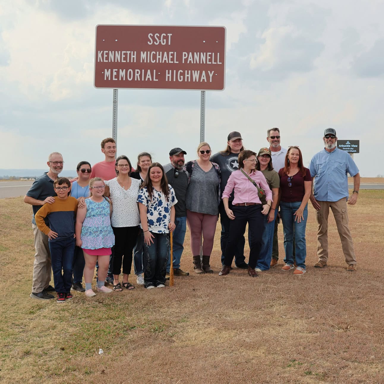 The family of Mike Pannell stand in front of new memorial highway sign.