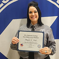 woman holds up a certificate.