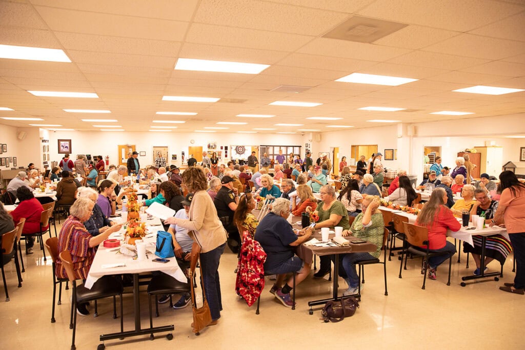 A large group of people fill a community center.