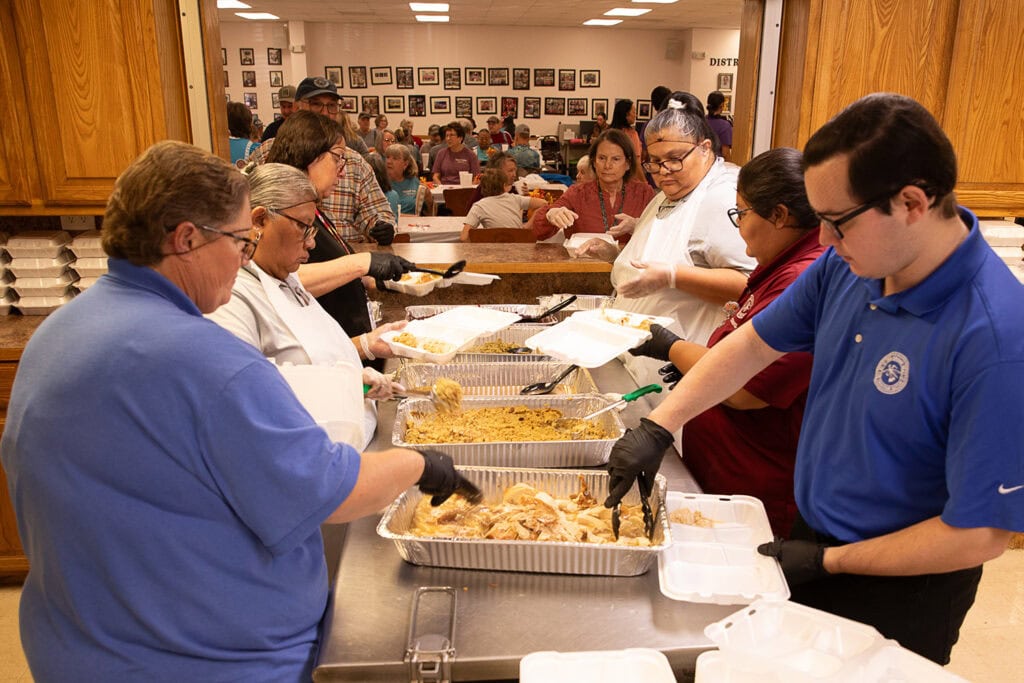 Servers prepare plates.