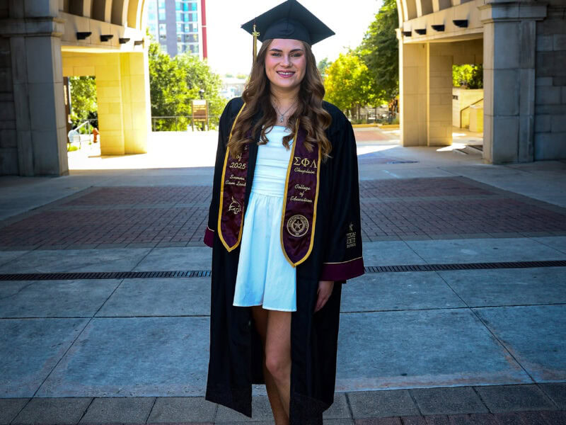 Young woman dressed in cap and gown.