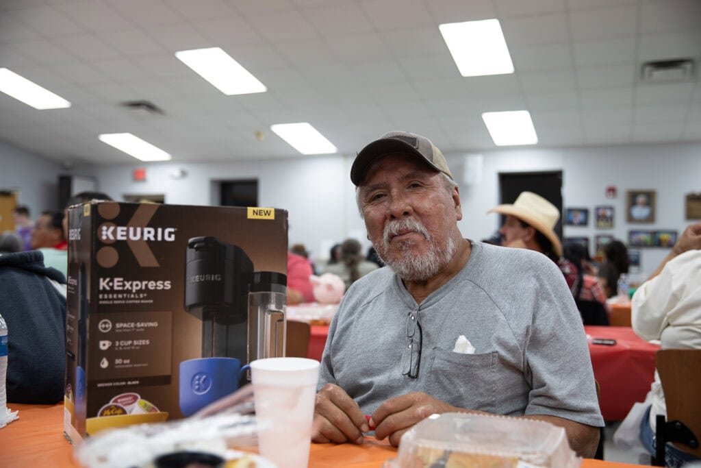 Man shows of his coffee maker prize.