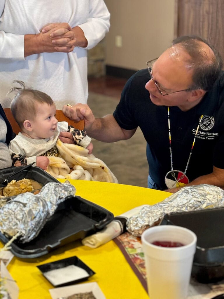 Chief speaks to a baby.