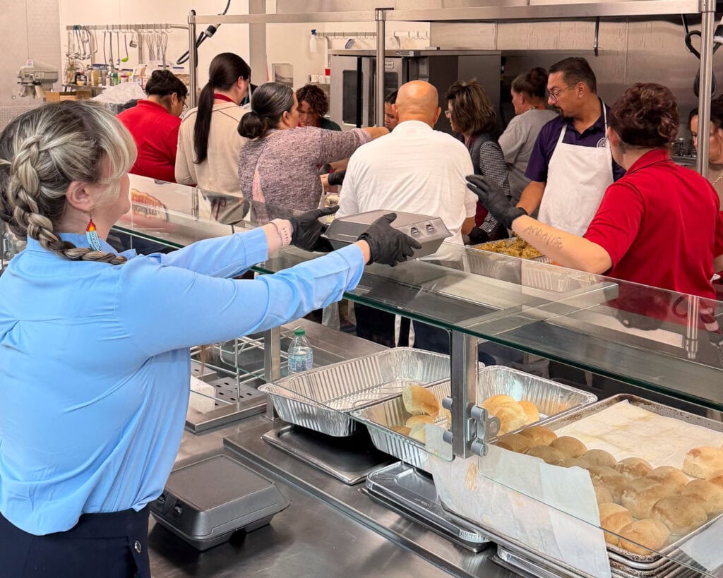 Volunteer grabs a meal from the serving line.