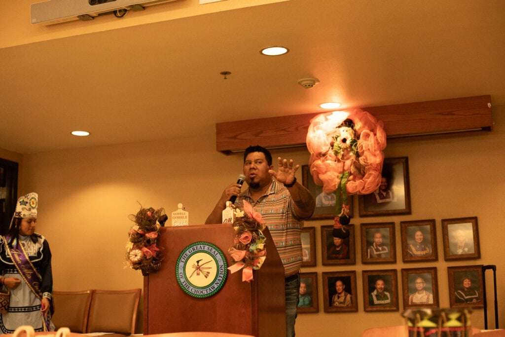 Joey Tom speaks at a podium.