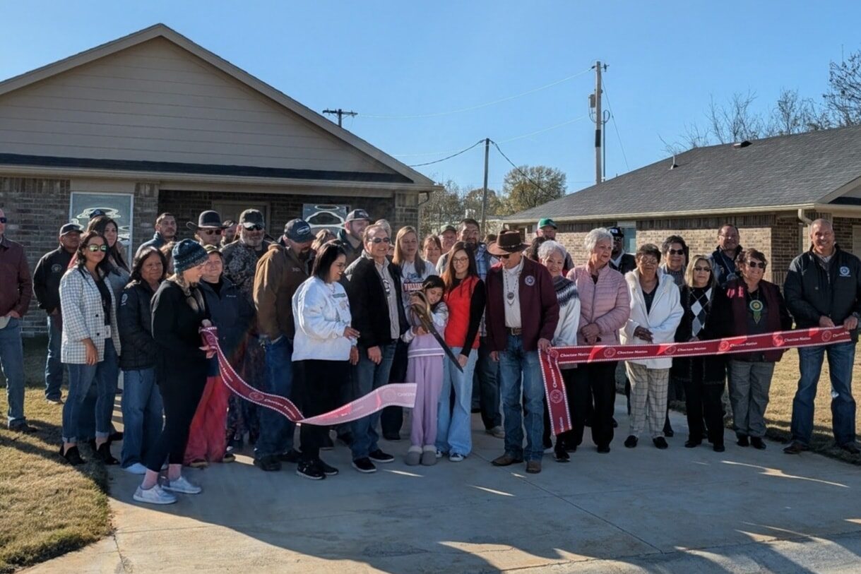 A large group of people cut a grand opening ribbon.