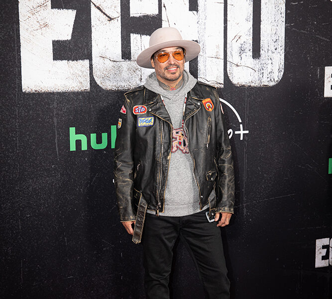 A man stands on the red carpet posing for pictures.