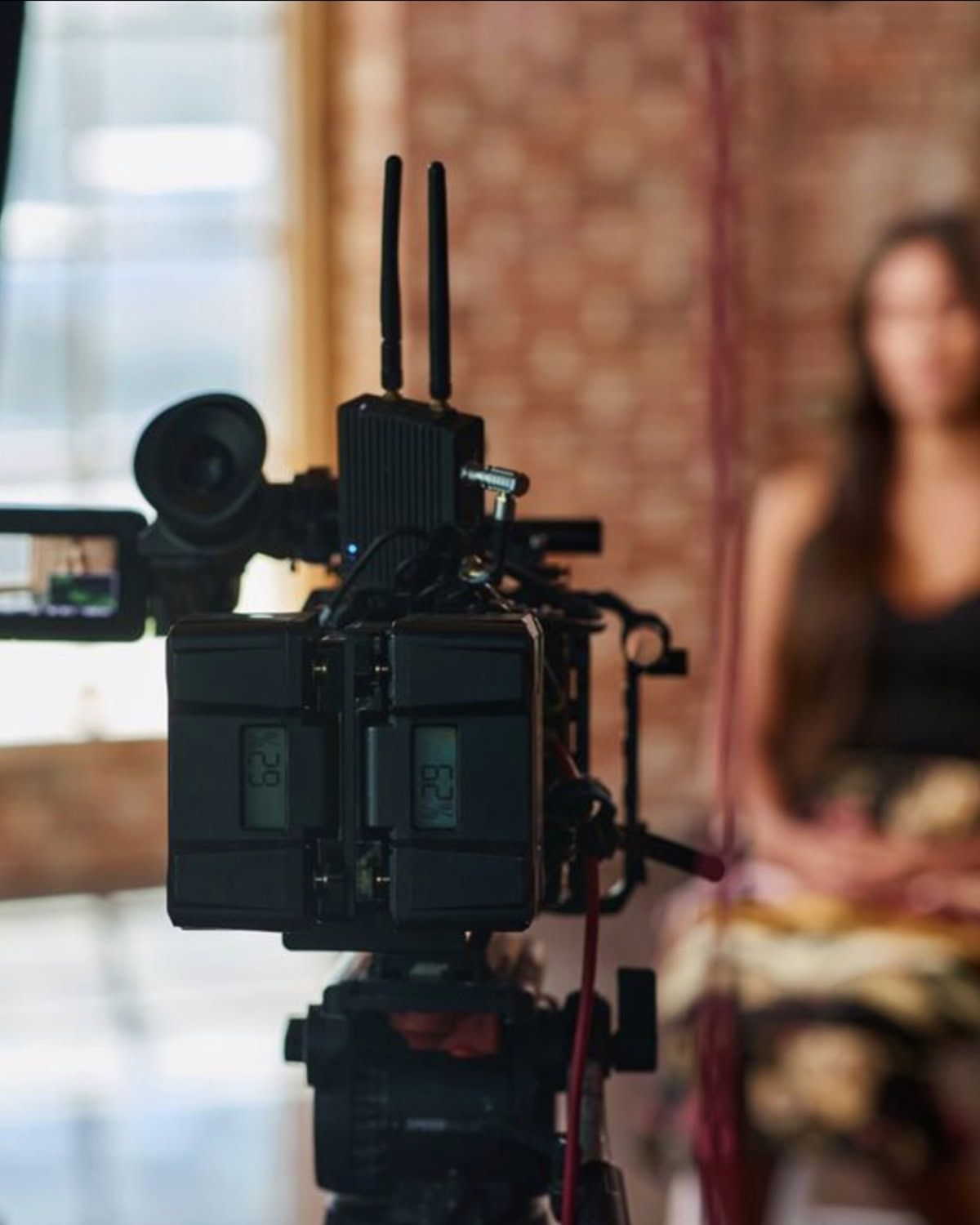 A camera films a woman sitting in a chair.