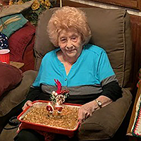 Woman holds birthday cake.