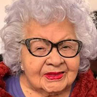 Woman wearing glasses smiles.