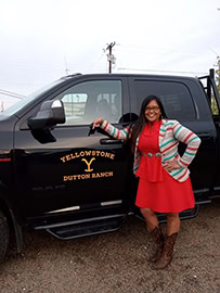 A woman stands next to a truck.