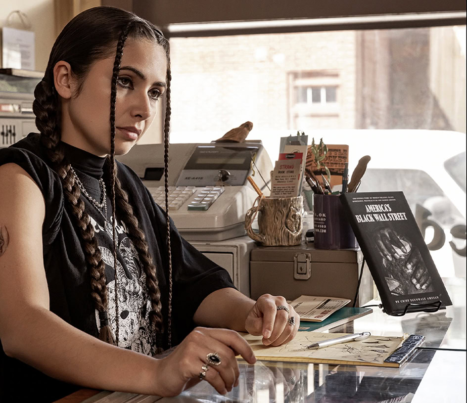 A scene from the TV series The Lowdown where a young Native American woman sits behind a counter.