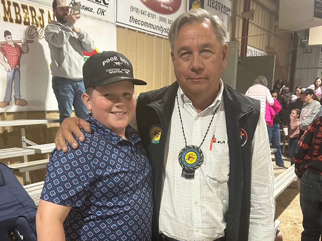 A man poses for a photo with a young man,