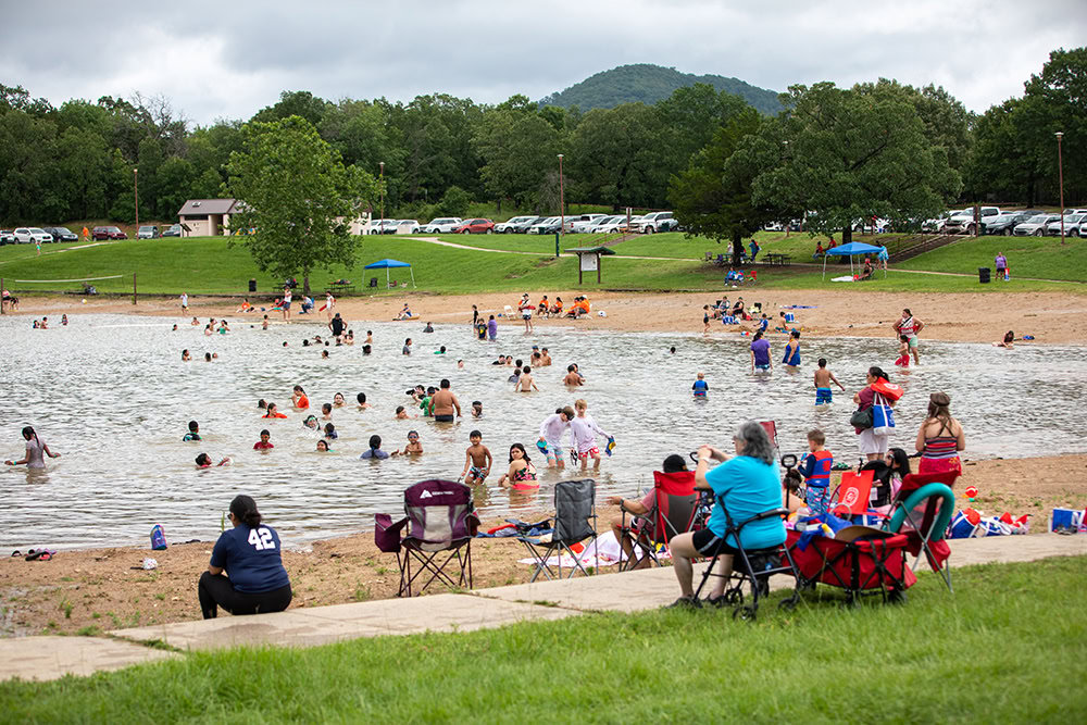 parents watch as kids swim in the lke.