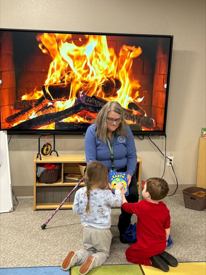 A women reads to two youngchildren