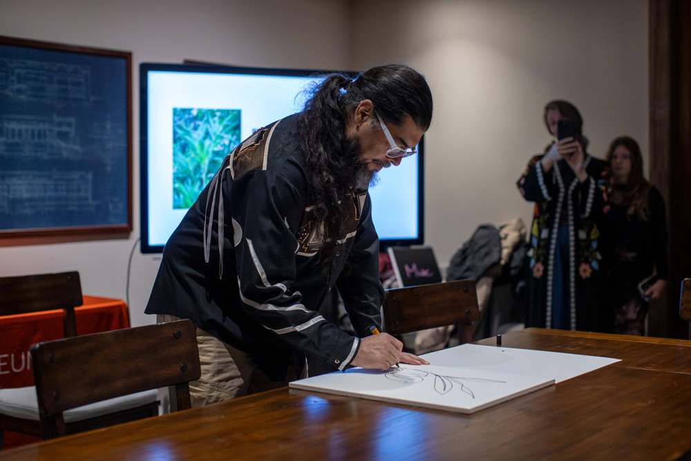 A Native man does a single-line drawing.