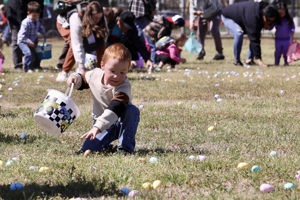 A young boy reaches for a golden egg.