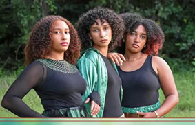 Three young women pose for a photo together.