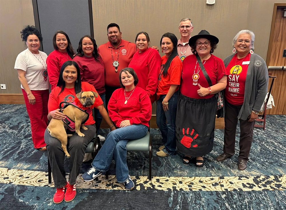 A group of people pose for a photo all wearing red. 