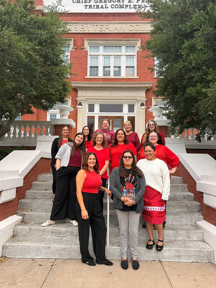 A group of people pose for a photo all wearing red. 