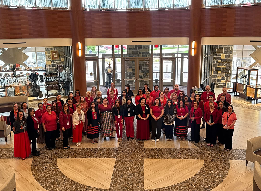 A group of people pose for a photo all wearing red. 