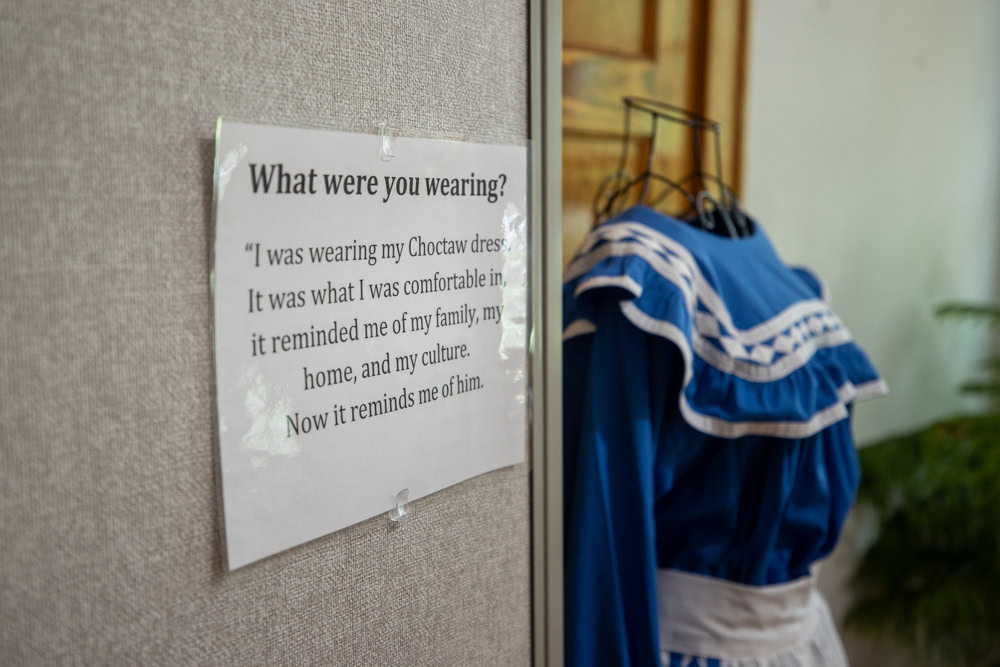 A blue dress next to a sign that says what were you wearing.