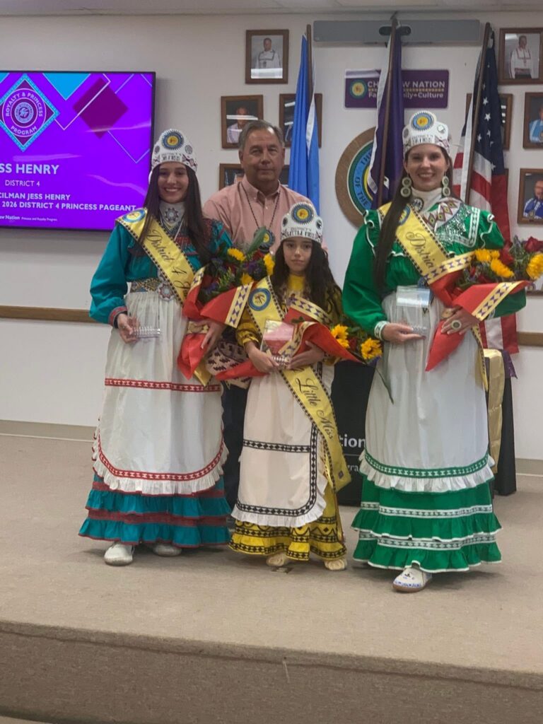 A man poses for a photo with Choctaw royalty.