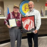 A man presents an elder with an award.