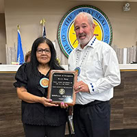 A man presents a woman with a plaque.